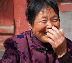 laughing_chinese Audience member reacts as Tim Geithner quips, "I just flew in from Washington, DC. And boy, are my arms tired."